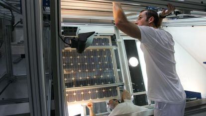 Un trabajador de Isofot&oacute;n manipula un panel solar.