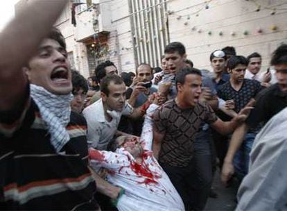 Un hombre herido por disparos de la milicia islámica es evacuado por otros manifestantes en Teherán.