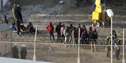 Un grupo de inmigrantes aguarda en Marruecos junto a la valla de Ceuta, este martes, tras no conseguir entrar en Espa&ntilde;a.