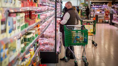 Un consumidor mira productos en un supermercado de Madrid.