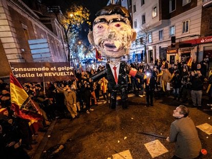 Un hombre se prepara para golpear un muñeco de Pedro Sánchez, la pasada Nochevieja cerca de la sede del PSOE en Madrid.