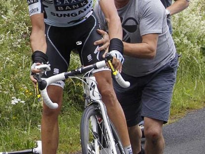 Alberto Contador es ayudado por su equipo a cambiar de bicicleta.