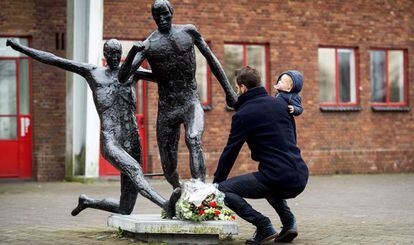 Un hombre deposita flores en la estatua de Johan Cruyff en el estadio Ol&iacute;mpico de Amsterdam donde juega el Ajax.