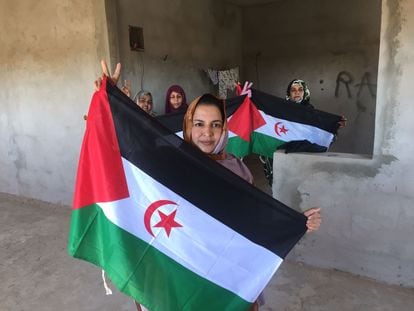 Sultana Jaya posa en su casa de Bojador con la bandera de la República Árabe Saharaui Democrática, acompañada de otras militantes pro Frente Polisario, el 26 de marzo.