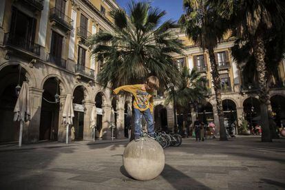 Un nen juga a la plaça Reial de Barcelona, un dels llocs més turístics.