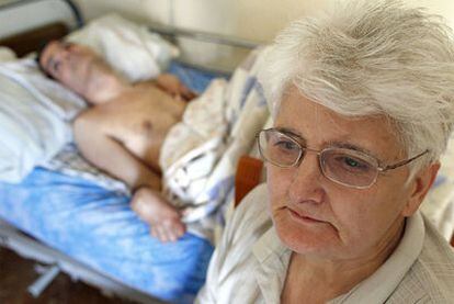 Juana Ortega, madre de Antonio Meño, a los pies de la cama donde descansa su hijo en una habitación de su casa en Móstoles.