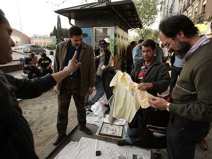 Clientes examinan la mercancía de un puesto de venta ilegal en Atocha.