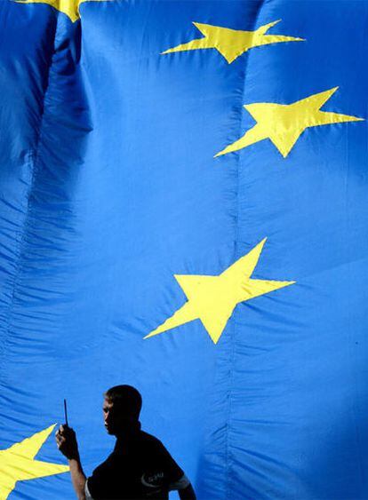 Un trabajador, ante una bandera de la UE en Bruselas.