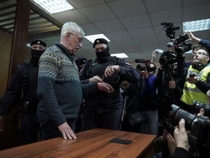 Un agente de policía pone las esposas al activista de la organización Memorial Oleg Orlov, durante una vista judicial en Moscú, el 27 de febrero.