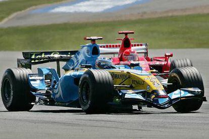 Fernando Alonso toma uno de los virajes del circuito de Silverstone por delante de Michael Schumacher.