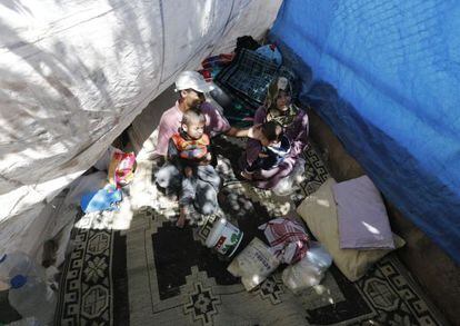 Una familia de refugiados sirios permanece en una tienda improvisada r, en la frontera sirio-turca.