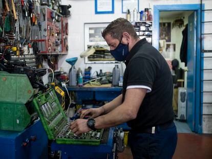 Un mecánico trabaja en su taller de mecánica de coches en Sevilla.