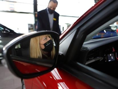 Una mujer comprueba el interior de un vehículo en un concesionario de Terrassa.