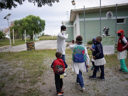 Un maestro saluda a sus alumnos en una escuela rural tras un mes de baja por la covid-19 en San José, Uruguay.