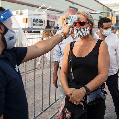 MADRID, SPAIN - JULY 07: A woman  has her temperature checked by a security guard at the entrance of Abre Madrid Festival 2020 at IFEMA on July 07, 2020 in Madrid, Spain. Abre Madrid Festival is an open air festival organized at IFEMA venue, with entertainment events that include concerts, monologues and many other activities. This is the first festival to be held in IFEMA since being used as an Emergency Hospital for coronavirus (COVID-19) patients. (Photo by Javier Bragado/Getty Images)