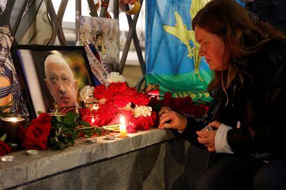 Una mujer enciende una vela frente a un retrato del jefe de los mercenarios de Wagner, Yevgueni Prigozhin, en un monumento improvisado en Moscú, este jueves.