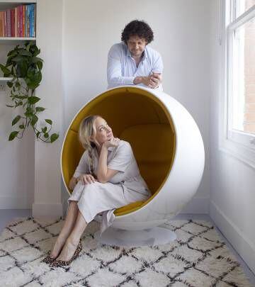 Henrietta Thompson y Ed Padmore, posan en un interior amueblado con sus piezas de alquiler, entre ellas, la icónica silla Ball de Eero Aarnio. |