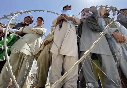 Un grupo de afganos, algunos de ellos extrabajadores de la OTAN, la Unión Europea y la ONU, esperan en las afueras del aeropuerto de Kabul para intentar abandonar el país.