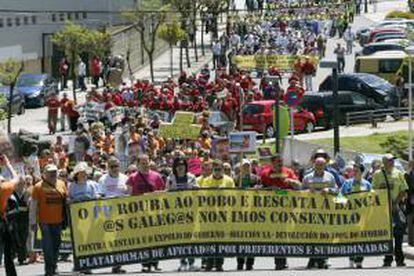 Asistentes a la manifestación convocada por las plataformas de afectados por preferentes y subordinadas de Galicia que ha recorrido las calles de Santiago de Compostela y que concluye en la residencia oficial del presidente de la Xunta.