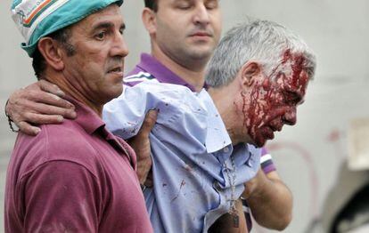 El maquinista Francisco José Garzón es ayudado por dos vecinos de Angrois tras el accidente.