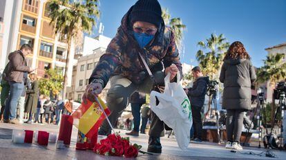 Una mujer coloca una bandera en el lugar donde fue asesinado el sacristán Diego Valencia, en Algeciras (Cádiz).
