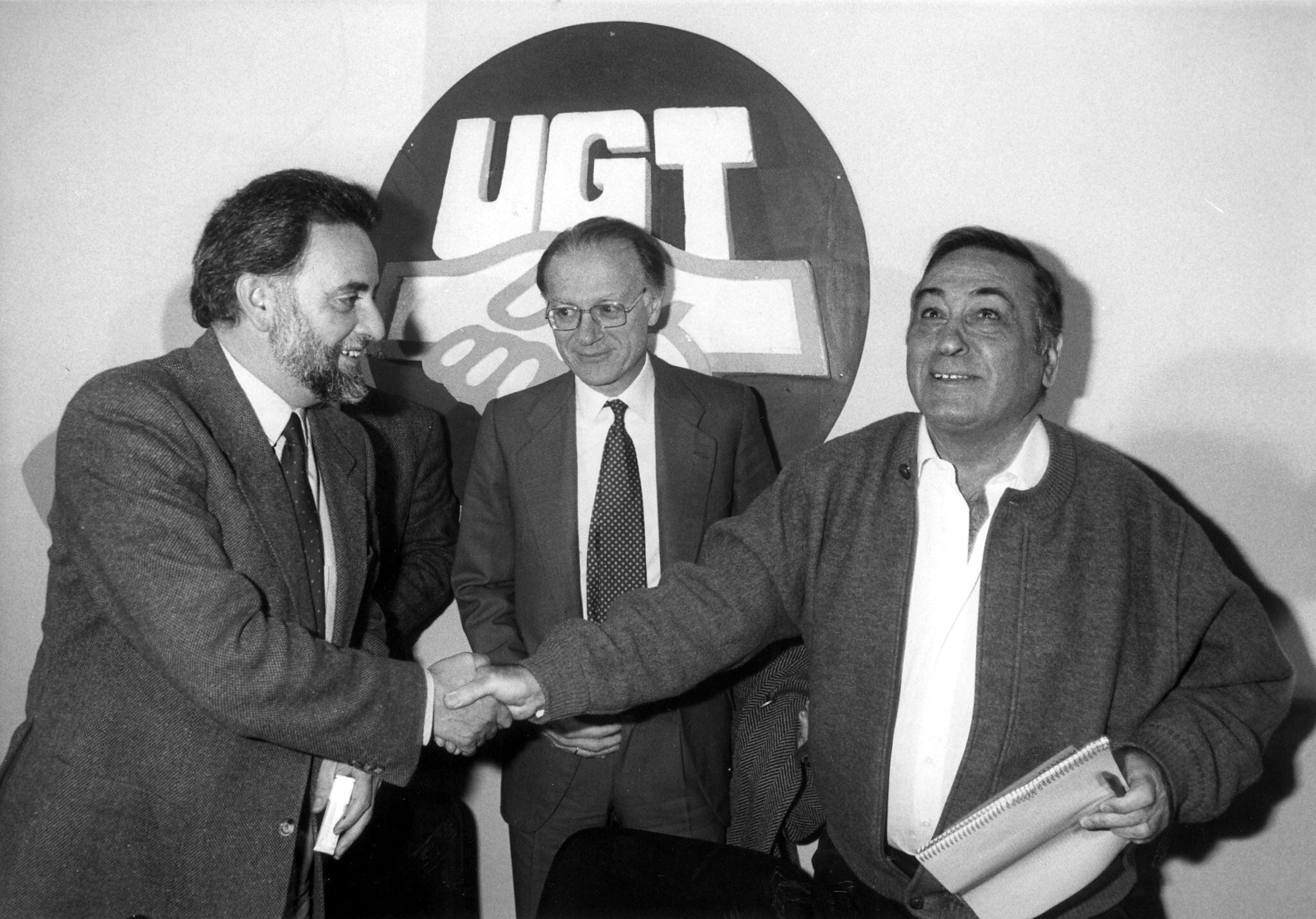 El secretario general de UGT, Nicolás Redondo (a la derecha), y el presidente de Izquierda Unida, Julio Anguita, se estrechan la mano en presencia de Nicolás Sartorius, en 1990.