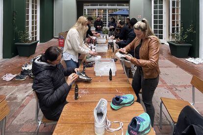 Un grupo de voluntarios limpia zapatillas deportivas que luego donarán a personas sin hogar durante el Día Internacional de Mandela, el 18 de julio de 2022, en Ciudad del Cabo, Sudáfrica.