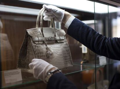 Un empleado Heritage Auctions de Beverly Hills deposita el bolso Hermès Himalayan Birkin en una vitrina.Se creó en exclusiva para la apertura de la tienda Louis Vuitton en Hong Kong en 2008, y solo hay 88 copias en todo el mundo.