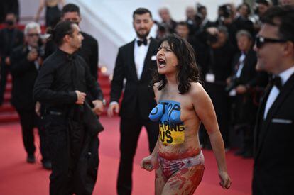Una mujer con los colores nacionales ucranianos pintados en el cuerpo protesta en la alfombra roja de Cannes durante la proyección de la película 'Tres mil años de anhelo'.