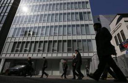 Trabajadores caminan junto al edificio en el que se encuentra el sitio de intercambio de bitcoins Mt. Gox en Tokio (Japón). EFE/Archivo