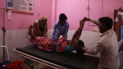 Familiares de Zamerun Nisha, de 33 años, depositan a la mujer en una camilla, después de que se sometiera a una cirugía de esterilización en un centro sanitario de Bahadurganj, en el noreste de India, el 21 de marzo de 2023.