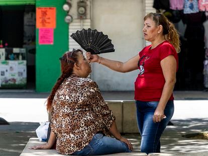 Personas se abanican en el Paseo Alcalde, de Guadalajara, Jalisco, debido a las altas temperaturas.