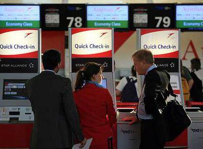 Pasajeros de Austrian Airlines sacan la tarjeta de embarque en el aeropuerto de Viena.