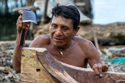 An artisan makes a handmade boat, in a Panamanian maritime community.