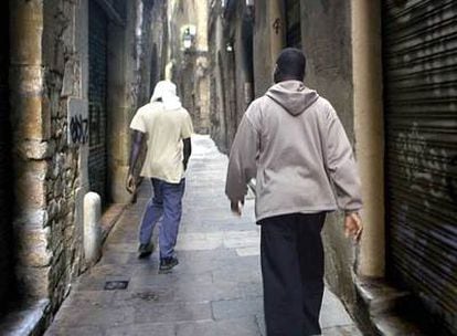 Dos inmigrantes caminan por una calle de Barcelona.