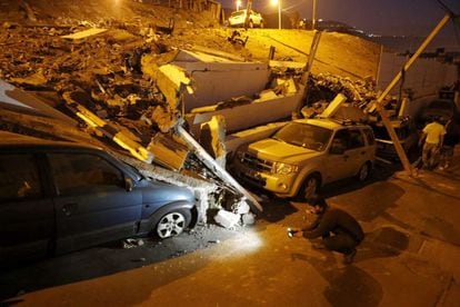 Un hombre graba los destrozos de unos vehículos en la Iquique (Chile), 2 de abril.