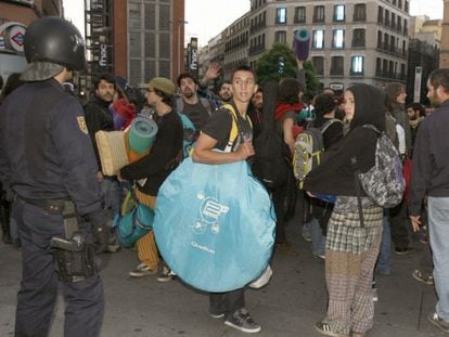 Agentes de Policía custodian en Callao a uno de los grupos de las que estaban acampadas en la madrileña Puerta del Sol.