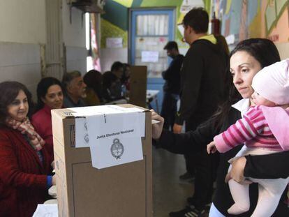 Argentinos votan ante la mirada de autoridades de mesa y fiscales en las primarias de agosto.