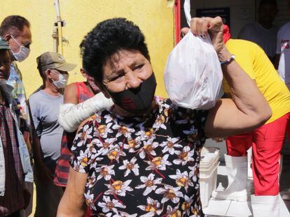 Una mujer muestra sus bolsas con huesos a las afueras de un expendio de carne el 21 de julio en Cuiabá.