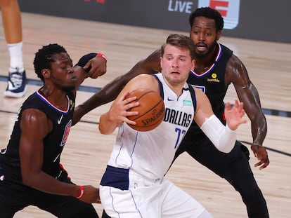 Luka Doncic, entre Reggie Jackson y JaMychal Green.