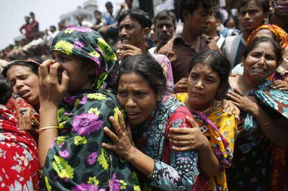 Unas mujeres esperan saber de sus familiares que se encuentran atrapados entre los escombros del edificio de ocho plantas derrumbado en Dacca (Bangladesh). Según los medios locales, hasta 2.000 personas se encontraban en el edificio, que también acogía un mercado y tiendas de electrónica, en el momento en el que se derrumbó.