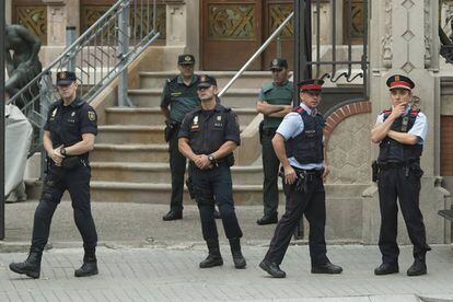 Miembros de la Guardia Civil, de la Policía Nacional y de los Mossos d'esquadra en la puerta de la Delegación del Gobierno en Barcelona.