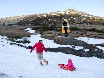 Javier Simón juega con su hija, junto a un cañón de nieve en Alto Campoó (Cantabria), el 22 de enero de 2024.