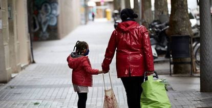 Una mujer y una niña caminan por el barrio de Gracia de Barcelona.