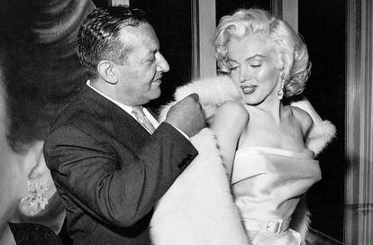 El dueño del bar Ciro’s de Los Ángeles ayuda a Marilyn Monroe a ponerse el abrigo, en 1957.