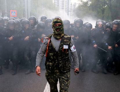 Un activista prorruso camina junto a unos policías ucranios en la ciudad de Donetsk (Ucrania).