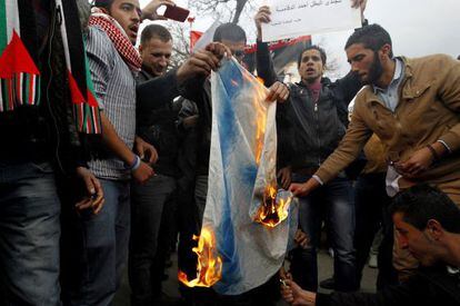 Manifestantes en Jordania queman una bandera de Israel en protesta por la muerte de un juez.