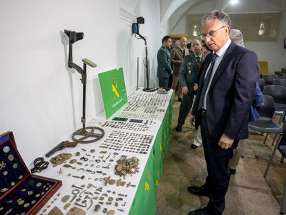 El delegado del Gobierno de Extremadura, José L. Quintana observa las monedas incautadas en la denominada 'Operación Tamussia', este martes en el Museo de Cáceres.