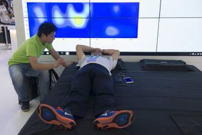 Un visitante prueba la cama inteligente de XSleep, que a través de multitud de sensores mantiene una posición correcta para dormir.
