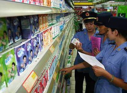 Inspectores chinos supervisan los lácteos de un supermercado.